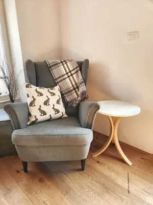a grey chair with a pillow and a table at Apartma 10th Mountain, Bovec in Bovec