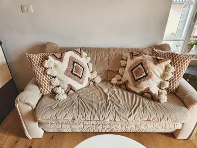 a brown couch with pillows on it in a living room at Apartma 10th Mountain, Bovec in Bovec
