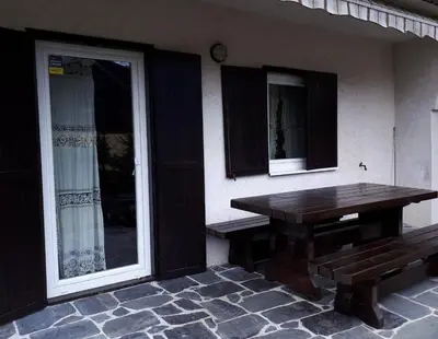 a wooden table and bench on the side of a house at Holiday House Jasna in Kranjska Gora
