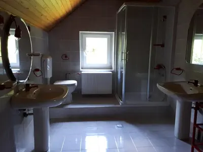 a bathroom with two sinks and a shower at Holiday House Jasna in Kranjska Gora