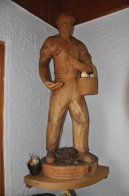 a statue of a man holding a basket of eggs at Penzion Kmečki Hram in Ljubljana
