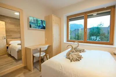 a bedroom with a bed and a desk and a window at Vila Alpina in Bled