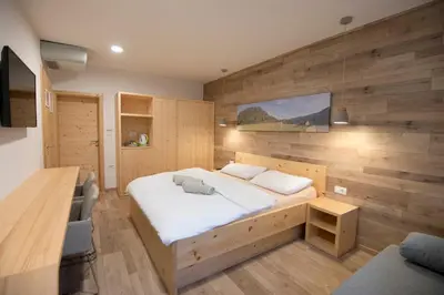 a bedroom with a bed and a wooden wall at Vila Alpina in Bled
