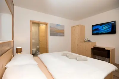 a bedroom with two beds and a flat screen tv at Vila Alpina in Bled