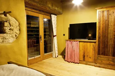 a bedroom with a flat screen tv and a window at Lavender Hill, Eko Resort & Wellness in Polzela