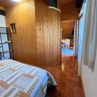 a bedroom with a bed and a wooden wall at Apartments Korošec Breda in Bohinj
