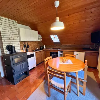 a kitchen with a wooden table and a stove at Apartments Korošec Breda in Bohinj