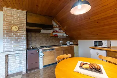 a kitchen with a table and a kitchen with a stove at Apartments Korošec Breda in Bohinj