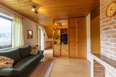 a living room with a couch and a brick wall at Apartments Korošec Breda in Bohinj
