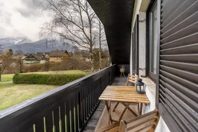 a porch with a wooden table and benches on a house at Apartments Korošec Breda in Bohinj