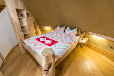 a bedroom with a wooden bed with a wooden floor at Apartma Zemljanka in Ljutomer
