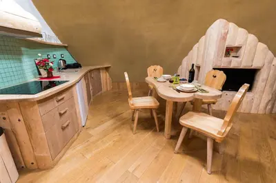 a kitchen with a table and chairs and a play kitchen at Apartma Zemljanka in Ljutomer