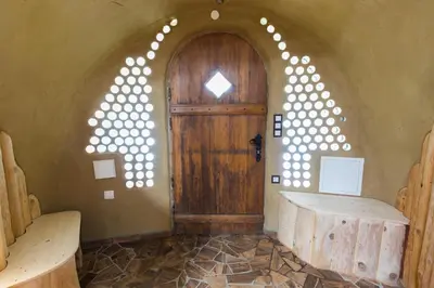 an arched doorway with a wooden door in a room at Apartma Zemljanka in Ljutomer