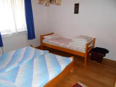 a bedroom with two twin beds and a window at Apartma Slavc in Kranjska Gora