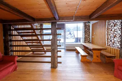 a room with a wooden staircase and a wooden table at House Budkovič in Bohinj