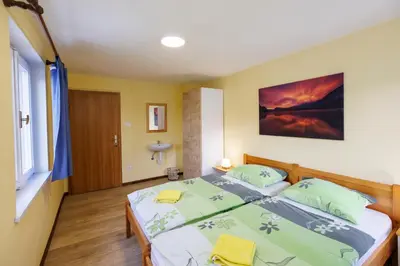 a bedroom with a large bed with green pillows at House Budkovič in Bohinj