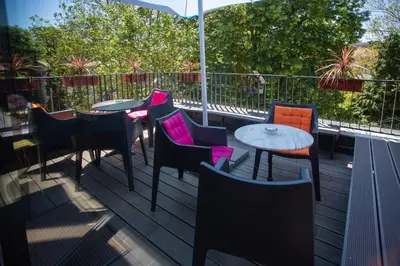 a patio with tables and chairs on a balcony at Hostel Pekarna in Maribor