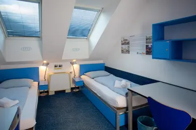 a hospital room with two beds and a table at Hostel Pekarna in Maribor