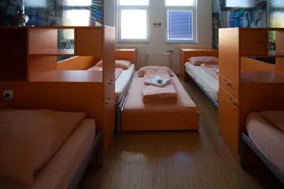 a small room with two bunk beds and a window at Hostel Pekarna in Maribor