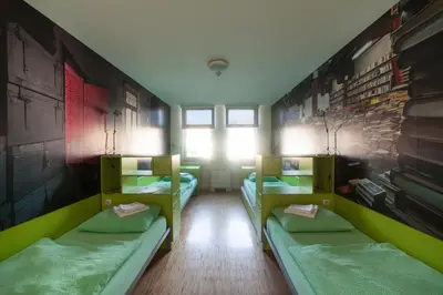 a room with three bunk beds and a window at Hostel Pekarna in Maribor