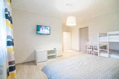 a bedroom with a bed and a desk and bunk beds at HOP HOUSE Garni Hotel in Postojna