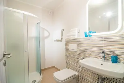 a bathroom with a toilet and a sink and a shower at HOP HOUSE Garni Hotel in Postojna