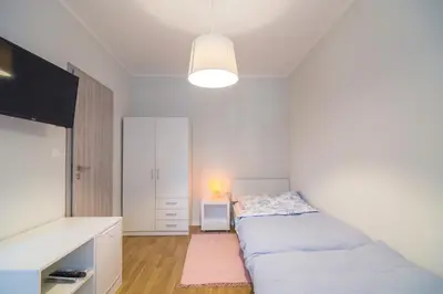 a white bedroom with a bed and a tv at HOP HOUSE Garni Hotel in Postojna