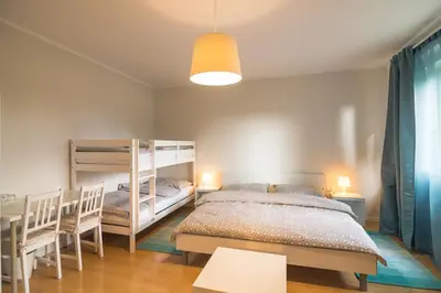 a bedroom with two bunk beds and a table at HOP HOUSE Garni Hotel in Postojna