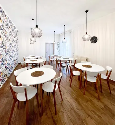 a group of tables and chairs in a room at HOP HOUSE Garni Hotel in Postojna