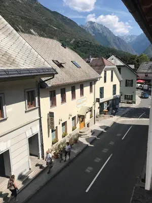 a group of people walking down a street next to buildings at Apartments Rombon in Bovec