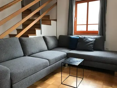 a living room with a couch and a staircase at Apartments Rombon in Bovec