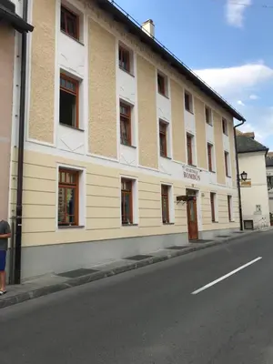 a large white building on the side of a street at Apartments Rombon in Bovec