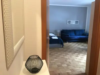 a living room with a blue couch and a table at Apartments Rombon in Bovec