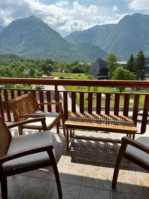 a balcony with two chairs and a table and chairs at Apartments Rombon in Bovec