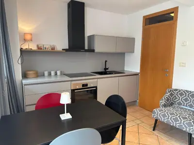 a small kitchen with a table and a couch at Apartments Rombon in Bovec