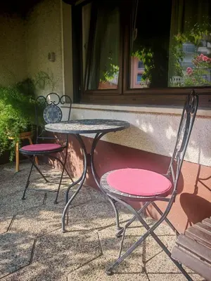 two chairs and a table in front of a building at Nauportus in Vrhnika