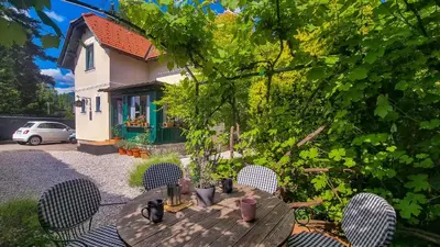 a wooden table and chairs in front of a house at Moja Vila Bled in Bled