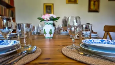 a wooden table with plates and wine glasses on it at Moja Vila Bled in Bled
