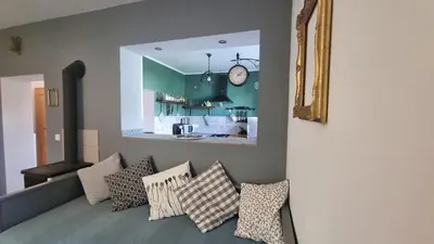 a living room with a couch with pillows and a clock at Moja Vila Bled in Bled