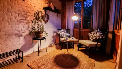 a living room with a table and chairs and a brick wall at Moja Vila Bled in Bled