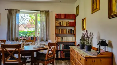 a dining room with a table and a book shelf at Moja Vila Bled in Bled