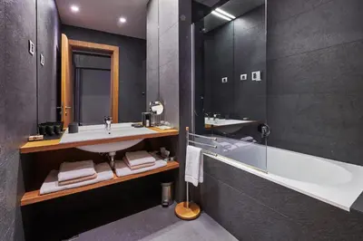 a bathroom with a sink and a bath tub at Gredič Heritage Residences in Dobrovo