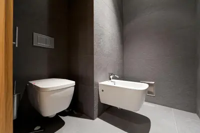 a bathroom with a white toilet and a sink at Gredič Heritage Residences in Dobrovo