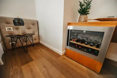 a room with a fireplace with a table and a lamp at Gredič Heritage Residences in Dobrovo
