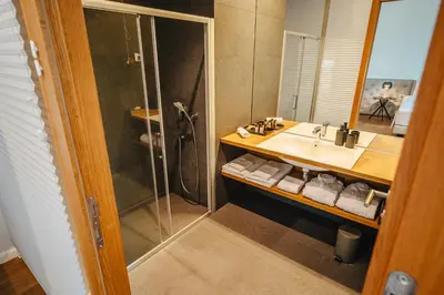 a bathroom with a sink and a shower at Gredič Heritage Residences in Dobrovo