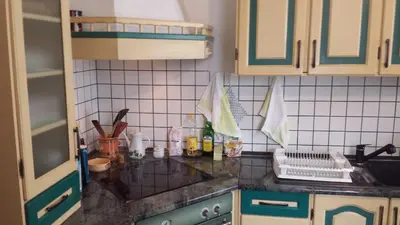 a kitchen with green and white tiles on the counter at Mama's House in Cerklje na Gorenjskem