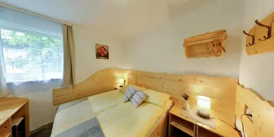 a bedroom with a wooden bed and a window at Mama's House in Cerklje na Gorenjskem