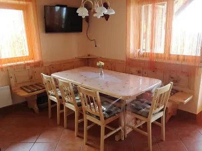 a dining room with a table and chairs and a tv at Apartmaji Vrhovnik in Cerklje na Gorenjskem
