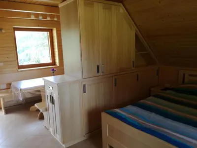 a bedroom with a bed and a desk in a cabin at Apartmaji Vrhovnik in Cerklje na Gorenjskem