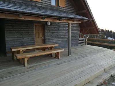 a wooden deck in front of a log cabin at Apartmaji Vrhovnik in Cerklje na Gorenjskem